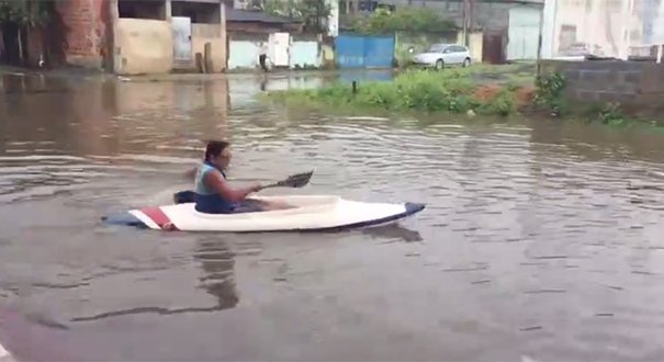 Moradores usam caiaque para sair de casa durante chuva em Vila Velha